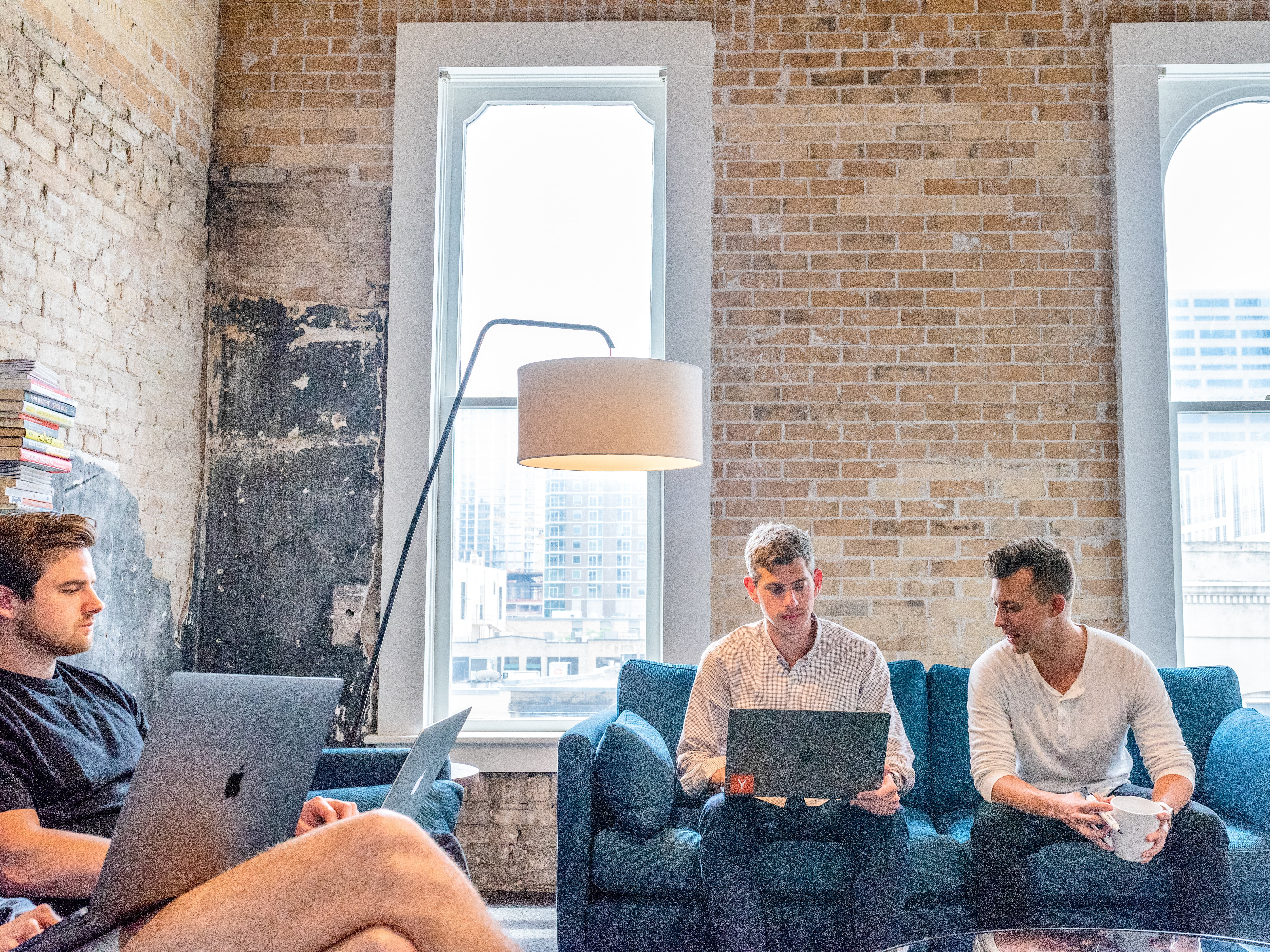 three men using macbooks